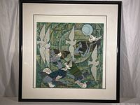 Framed art showing two blue-toned stylized female figures surrounded by birds in an abstract green background. Double mat and glass frame visible.