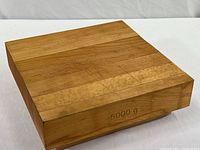 Top angled view of the thick, solid wood block cutting board showing use marks and natural wood grain.