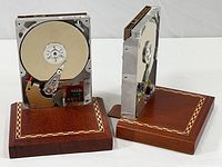 Pair of computer hard drive bookends with wood bases. Hard drives are open to show internal components. Bases have inlaid decorative trim.