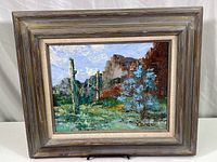 Framed original oil painting showing desert landscape with cacti and blue smoke tree, overall 21 x 18 in