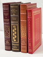Four Franklin Library hardcover books in a standing position showing spines and decorative gold embossing, colors include red, brown, and green tones.