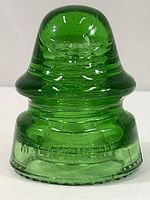 Full view of the green glass insulator showing its size and color