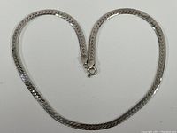 Full view of the vintage sterling silver necklace laid flat showing shape and clasp.