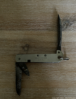 Photo showing the multi-tool pocket knife with both blades extended, highlighting the tool's form and condition.