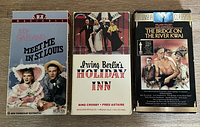 Front view of three VHS movie tape cases: Meet Me in St. Louis, Holiday Inn, The Bridge on the River Kwai