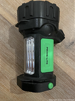 Front and side view showing the green Prime-Lite label, side panel light, and green button at base.