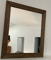Front view of the rectangular wood framed mirror showing the wooden frame and the reflective surface.