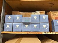 Ten blue Wedgwood branded boxes arranged on a shelf, indicating ten perfume bottles new in box.