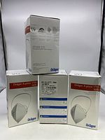 Four boxes of Dräger X-plore 1750 N95 masks stacked showing front and side labels, each box labeled with quantity 20 masks.