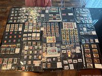 Wide view showing many pages of stamps in plastic sleeves, including U.S. presidents and international stamps.