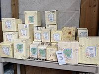 Multiple Cherished Teddies boxes arranged on shelves showing brand labels and decorative packaging.