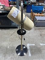 Full view of the mid-century floor lamp showing cream cylindrical shade and black base.