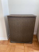 Front view of the rectangular woven hamper showing its patterned design and hinged lid.