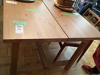 View of the top of the rectangular IKEA dining table showing the wood veneer surface and the seam where the extension leaf fits in.