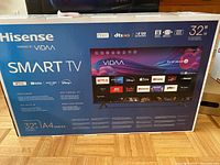 Front and side view of the boxed Hisense 32-inch A4 Series Smart TV showing model information, features, and apps supported.