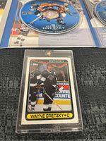 Front of 1990 Topps Wayne Gretzky #120 hockey card in hard plastic case, showing Gretzky in black Los Angeles Kings uniform holding hockey stick
