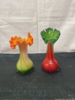 Full view of both Fenton blown glass vases side by side, showing their height, colors and ruffled tops.