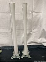 Front view of two tall glass tower vases with flared star-shaped bases and white frosted vertical accents.