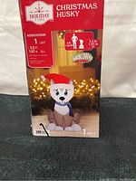 Front of box showing brand Holiday Time, product name Christmas Husky, specifications as 3.5 ft tall indoor/outdoor inflatable with light, airblown technology.