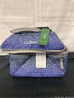 Front view of L.L.Bean soft side lunch bag with visible handle, zipper, and L.L.Bean logo with tags attached.