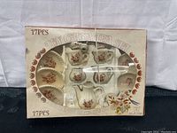 Front view of boxed vintage toy china tea set showing all pieces arranged inside the original packaging.