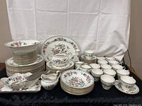 Full arrangement of plates, bowls, cups, serving pieces on table
