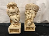 Front view of both busts showing facial features and base detail