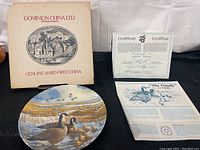 Photo showing the collector plate The Family by Donald Pentz, original box, and certificate of authenticity