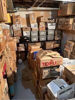 Overall view of room packed with stacked cardboard and plastic boxes