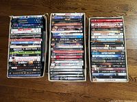 Three boxes of DVDs with various movie titles, stacked for viewing.
