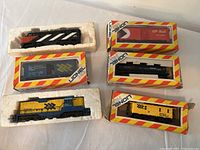 Several Lionel HO scale locomotives and rolling stock in original packaging and loose, showing variety of colors and railroad logos like CP Rail and Chessie System.