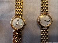 Front view of two gold-tone Seiko ladies watches showing dial details and linked bracelets.