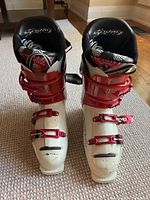 Top view of the Rossignol ski boots showing the red buckles, white shell, and Squad logo on padded liner.
