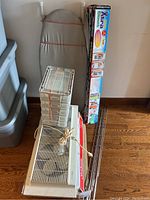 Portable ironing board with gray cover, stackable storage container with five drawers, two electric window fans, and three closet extender kits stacked vertically.