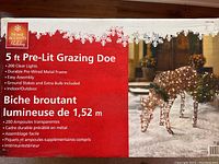 Box label showing 5 ft Pre-Lit Grazing Doe with 200 clear lights, durable metal frame, suitable for indoor/outdoor seasonal decoration.