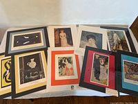 Nine 11×14 matted prints arranged on table showing sample of designs and mats