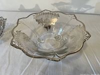 Glass bowl with sterling silver overlay featuring floral design, scalloped edges and clear glass base.