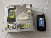 SkyCaddie SGXw golf GPS rangefinder beside its original box showing detailed product images and technology features including WiFi and unmatched accuracy.