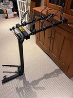 Full view of Thule 4-bike hitch-mounted carrier showing bike cradles, ratchet straps, and main frame structure.