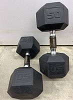 Overview shot showing two 50 lb rubber hex dumbbells on concrete floor