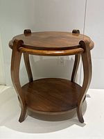Front view of two-tier round side table showing curved legs and two shelves