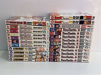 Photo showing the full lot of 24 manga graphic novels stacked to show spines and covers providing series and volume information.