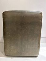 Tall vintage style ottoman upholstered in olive green leather from front and side views, showing smooth leather surface with natural wear and stitching details.