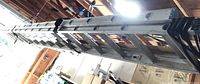 Two aluminum extension ladders stored horizontally in garage