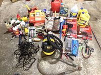 Full lot overview showing fluids, Stanley shop vac, jumper cables, funnels, and various tools and accessories.