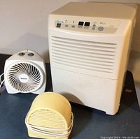 Photo showing all three appliances including the Comfort Aire dehumidifier, Holmes fan, and Patton fan in a grouping on a dark surface.