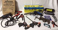 Full lot overview showing Milwaukee heat gun with box, Chicago Electric hot knife with box, assorted clamps and hand tools laid out