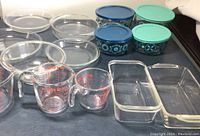 Overall view showing clear glass pie plates, mixing bowls, Pyrex measuring cups, and rectangular casseroles.