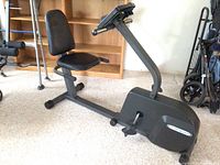 View of the full exercise bike showing seat, pedals, and structural frame.