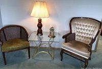 Two chairs, glass table, lamp, and brass clock together in room